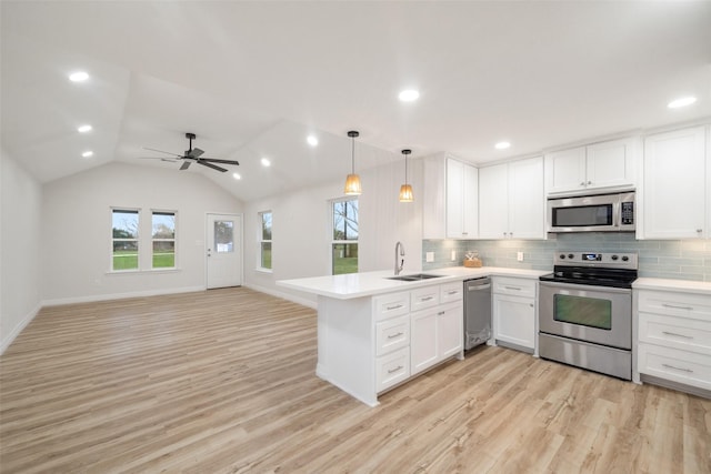 kitchen featuring sink, white cabinetry, decorative light fixtures, appliances with stainless steel finishes, and kitchen peninsula