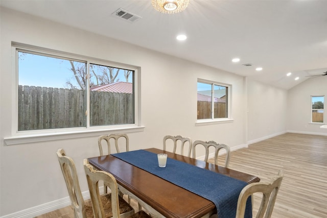 dining room featuring vaulted ceiling and light hardwood / wood-style floors