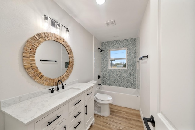 full bathroom with vanity, toilet, tiled shower / bath combo, and hardwood / wood-style floors