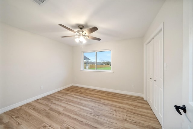 unfurnished bedroom with ceiling fan, a closet, and light wood-type flooring