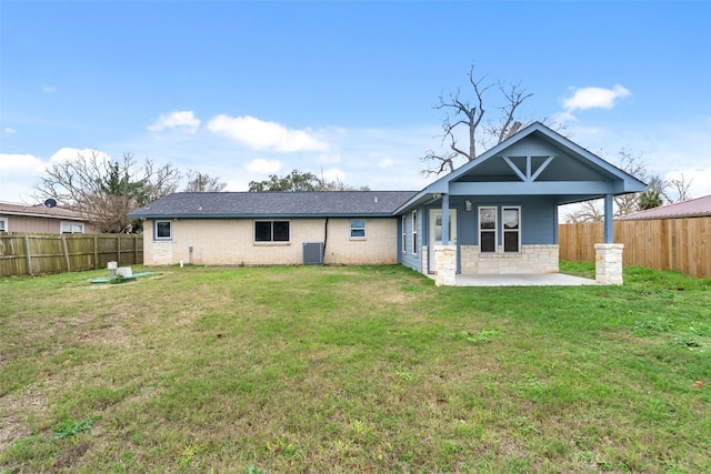 back of property featuring a lawn and a patio
