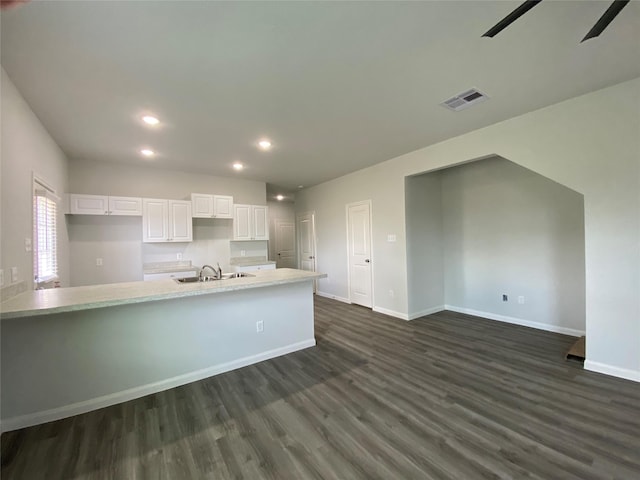 kitchen featuring sink, dark wood-type flooring, ceiling fan, white cabinetry, and an island with sink