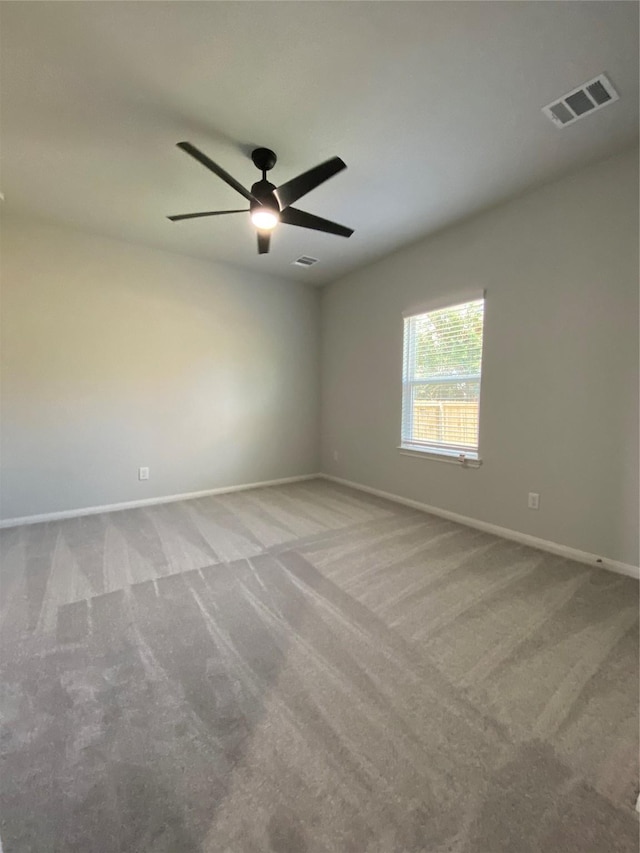 spare room with light colored carpet and ceiling fan