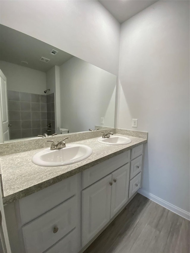 bathroom with vanity, a shower, wood-type flooring, and toilet