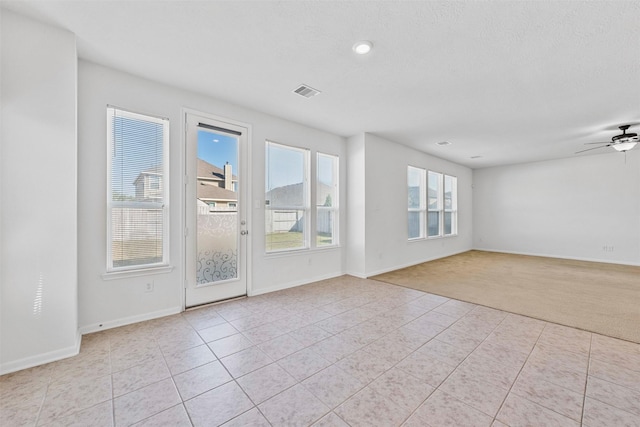 spare room with light tile patterned floors, a textured ceiling, and ceiling fan