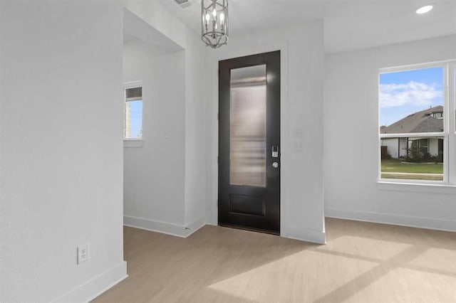 entrance foyer with an inviting chandelier and light wood-type flooring