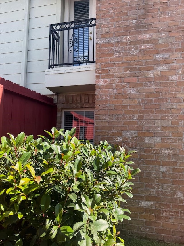 details featuring fence and brick siding