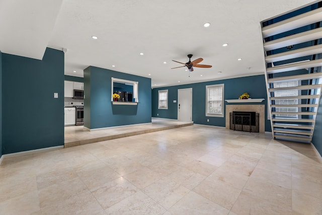 unfurnished living room with a textured ceiling, recessed lighting, a fireplace, a ceiling fan, and baseboards