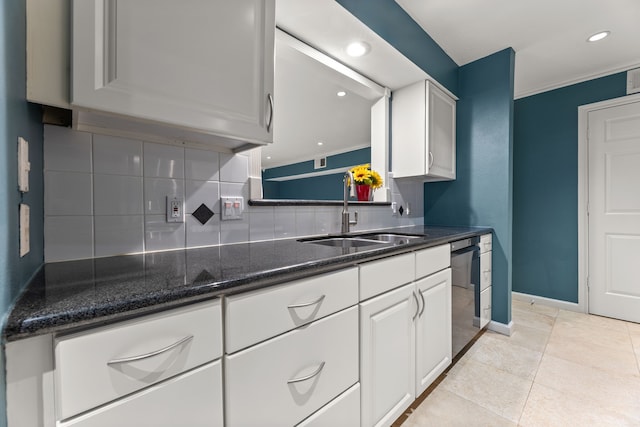 kitchen with black dishwasher, decorative backsplash, a sink, and white cabinets