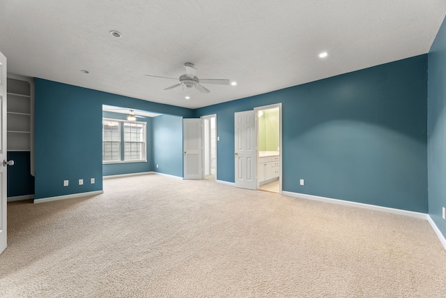 unfurnished bedroom featuring recessed lighting, light colored carpet, a textured ceiling, and baseboards