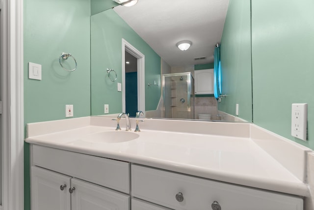 bathroom featuring toilet, a stall shower, visible vents, and vanity