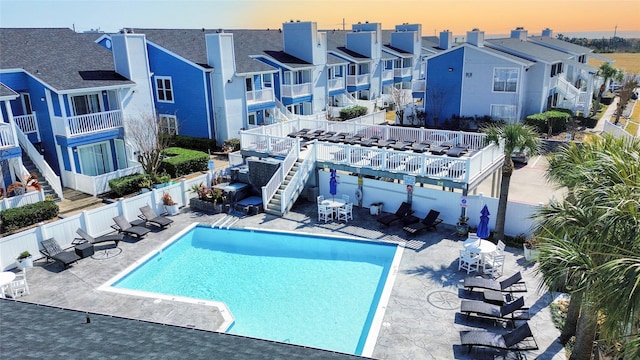 pool at dusk with a patio area