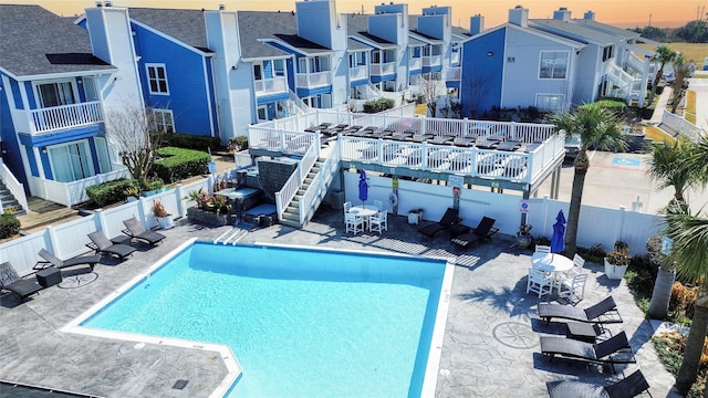 pool at dusk featuring a patio