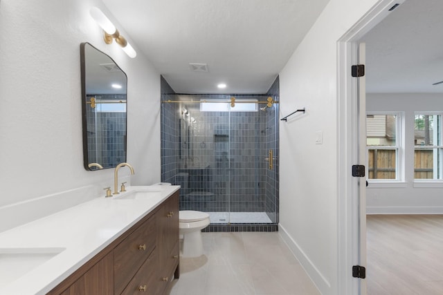 bathroom with vanity, a shower with shower door, and toilet