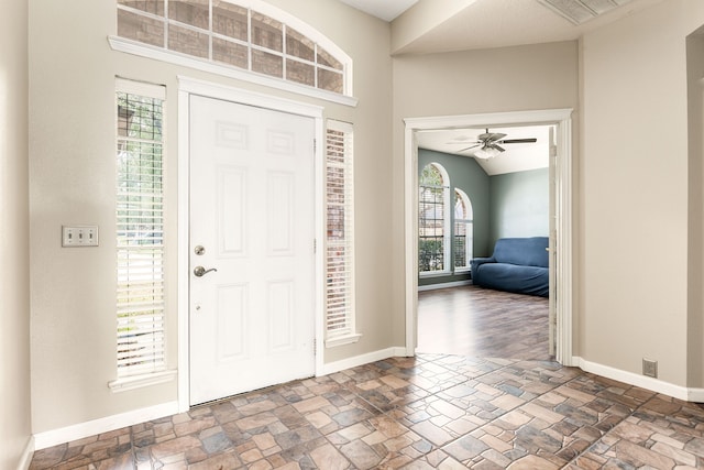 entrance foyer with vaulted ceiling, a healthy amount of sunlight, and ceiling fan