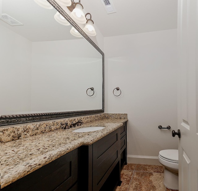bathroom featuring toilet, visible vents, vanity, and baseboards