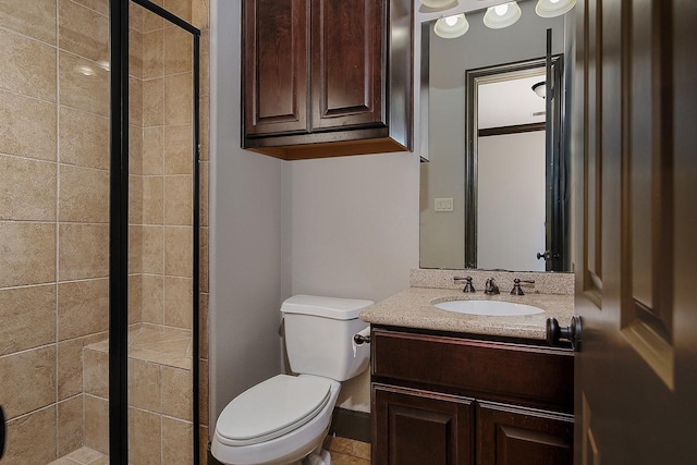 bathroom featuring vanity, toilet, and a stall shower