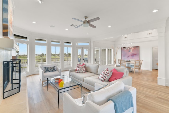 living room with french doors, ceiling fan with notable chandelier, and light hardwood / wood-style flooring