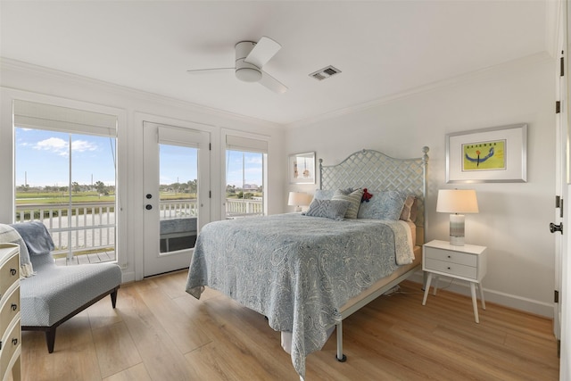 bedroom featuring multiple windows, ornamental molding, access to outside, and light hardwood / wood-style floors