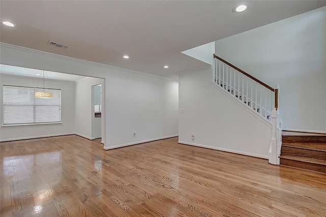 unfurnished living room with crown molding and light hardwood / wood-style flooring