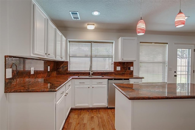 kitchen with white cabinetry, dishwasher, sink, and decorative light fixtures