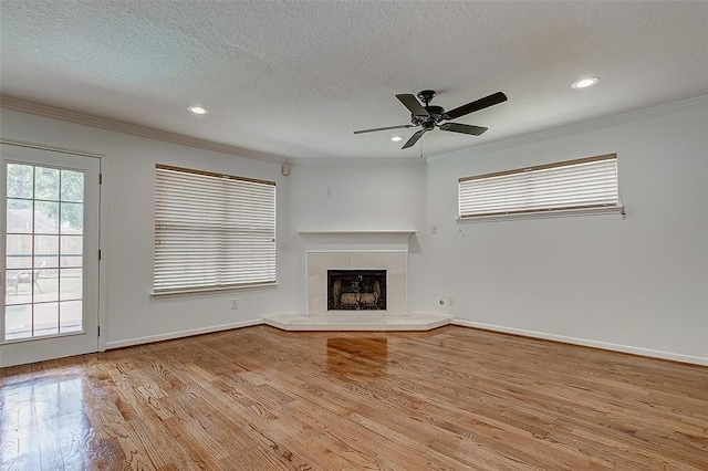 unfurnished living room with ceiling fan, ornamental molding, light hardwood / wood-style floors, and a textured ceiling