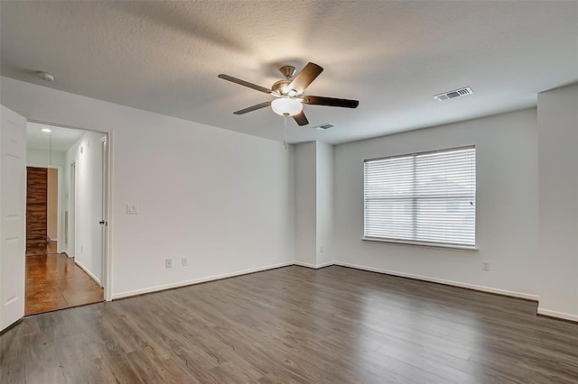 spare room with ceiling fan, dark hardwood / wood-style flooring, and a textured ceiling