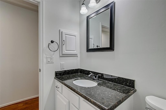 bathroom featuring vanity, wood-type flooring, and toilet