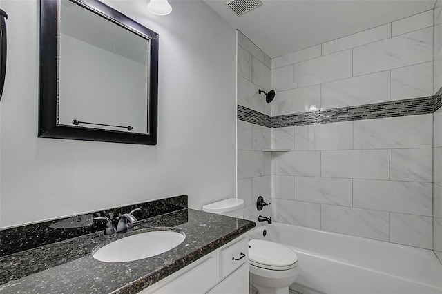 full bathroom with tiled shower / bath, vanity, and toilet