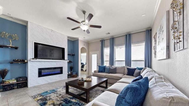 tiled living room with ceiling fan and ornamental molding