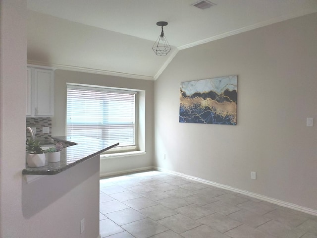 unfurnished dining area with lofted ceiling and crown molding