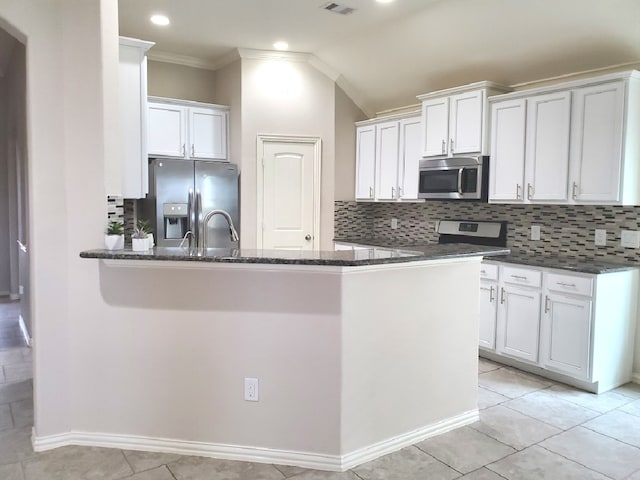 kitchen featuring tasteful backsplash, appliances with stainless steel finishes, white cabinets, and kitchen peninsula