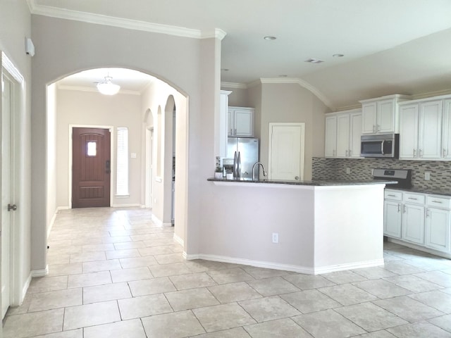 kitchen featuring white cabinetry, ornamental molding, appliances with stainless steel finishes, and decorative backsplash