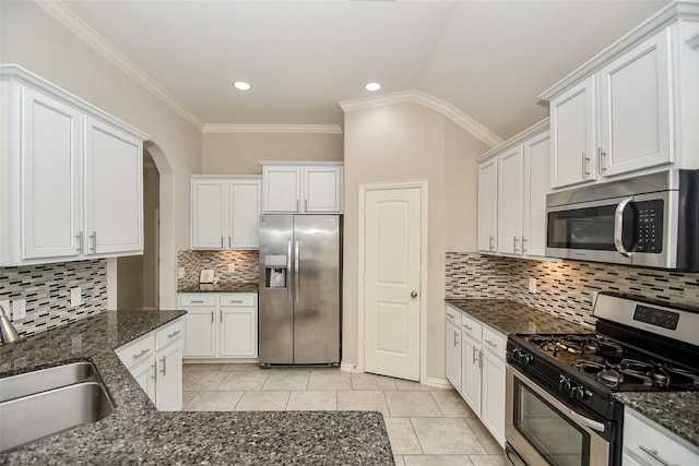 kitchen featuring stainless steel appliances, sink, white cabinets, and dark stone counters