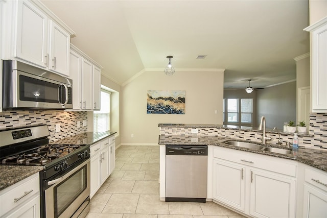 kitchen featuring white cabinetry, stainless steel appliances, sink, and dark stone countertops