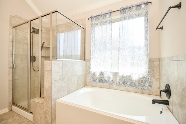 bathroom with ornamental molding and separate shower and tub