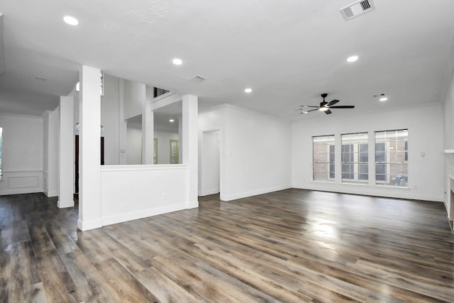 unfurnished living room with a healthy amount of sunlight, ornamental molding, dark wood-type flooring, and ceiling fan