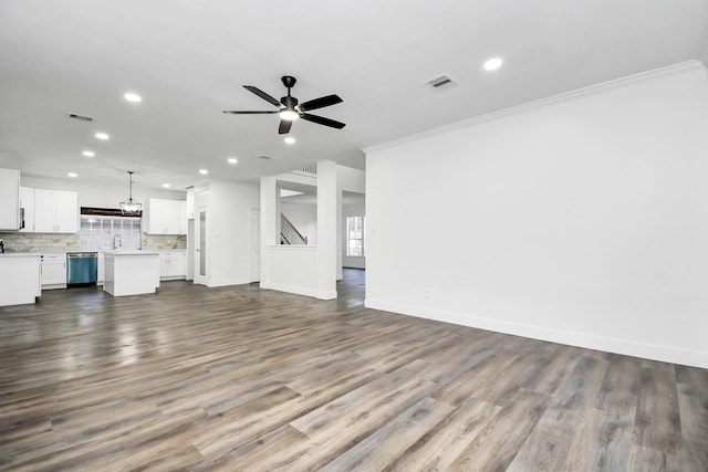 unfurnished living room featuring crown molding, sink, hardwood / wood-style flooring, and ceiling fan