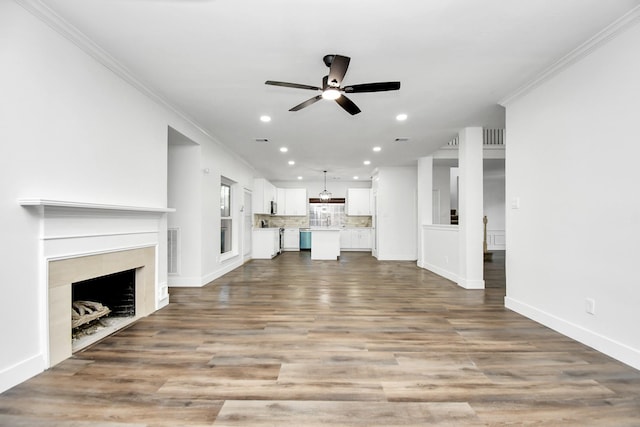 unfurnished living room featuring hardwood / wood-style flooring, ornamental molding, and ceiling fan