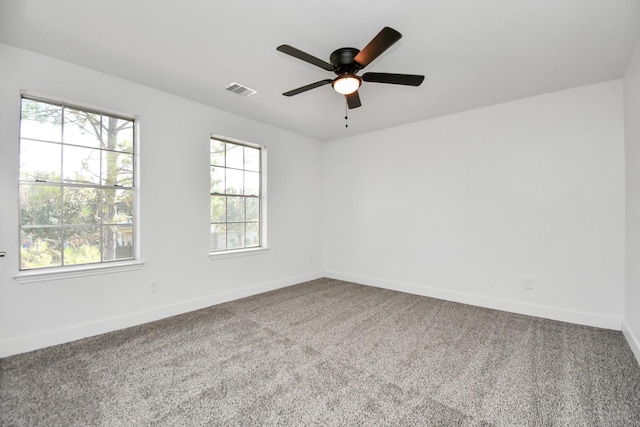 carpeted spare room with a wealth of natural light and ceiling fan