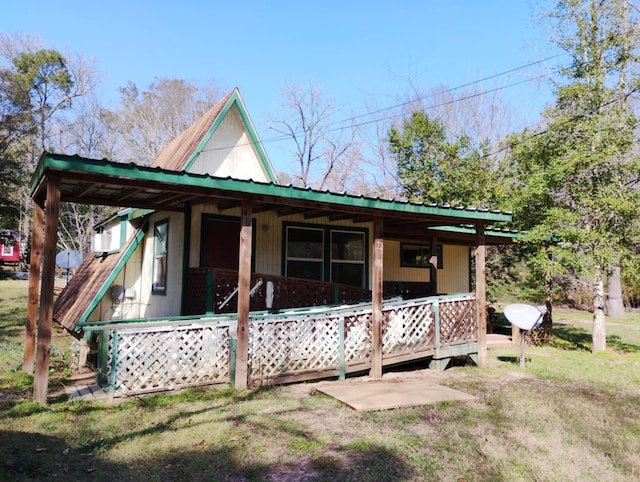 view of front of property with a front yard, covered porch, and metal roof
