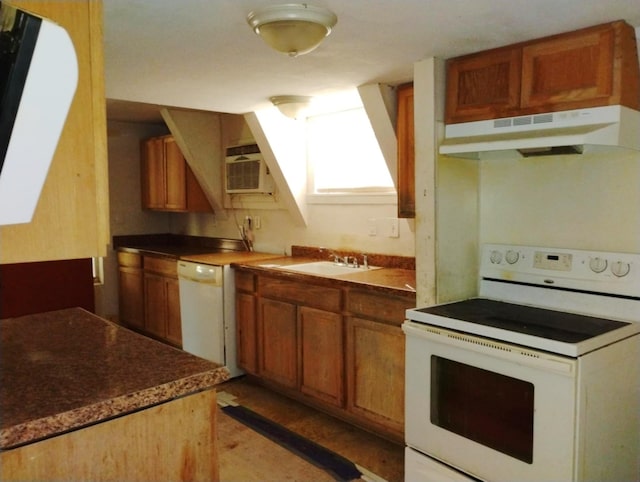 kitchen featuring under cabinet range hood, white appliances, a sink, an AC wall unit, and brown cabinetry