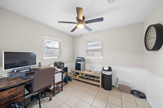 tiled office featuring a textured ceiling and ceiling fan