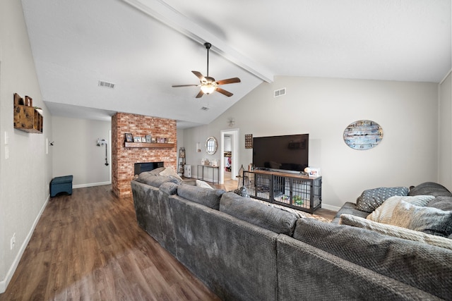 living room featuring dark wood-type flooring, ceiling fan, lofted ceiling with beams, and a brick fireplace