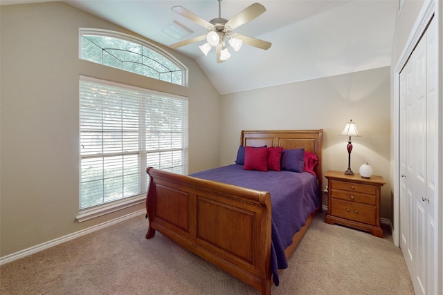 bedroom with vaulted ceiling, light colored carpet, and a closet