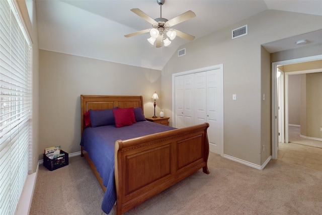 carpeted bedroom with lofted ceiling, a closet, and ceiling fan