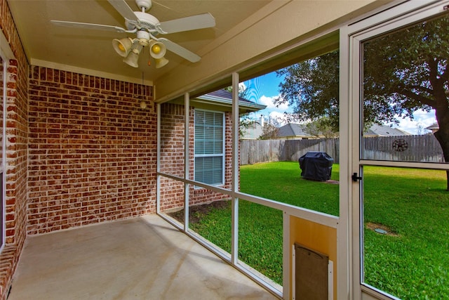 unfurnished sunroom featuring ceiling fan