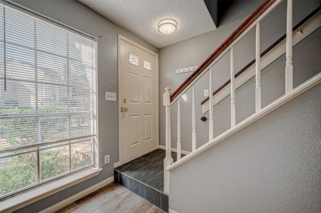 entryway with hardwood / wood-style flooring and a textured ceiling