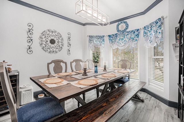 dining room with ornamental molding, hardwood / wood-style floors, and wine cooler