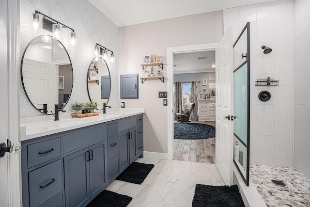 bathroom with vanity and tiled shower